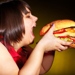 Obese woman eating a hamburger
